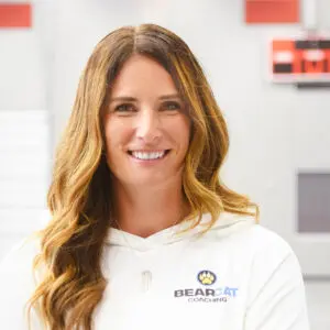 Cathy Helin in a white polo indoors, confident representing mindset coaching for athletes, parents, and coaches.