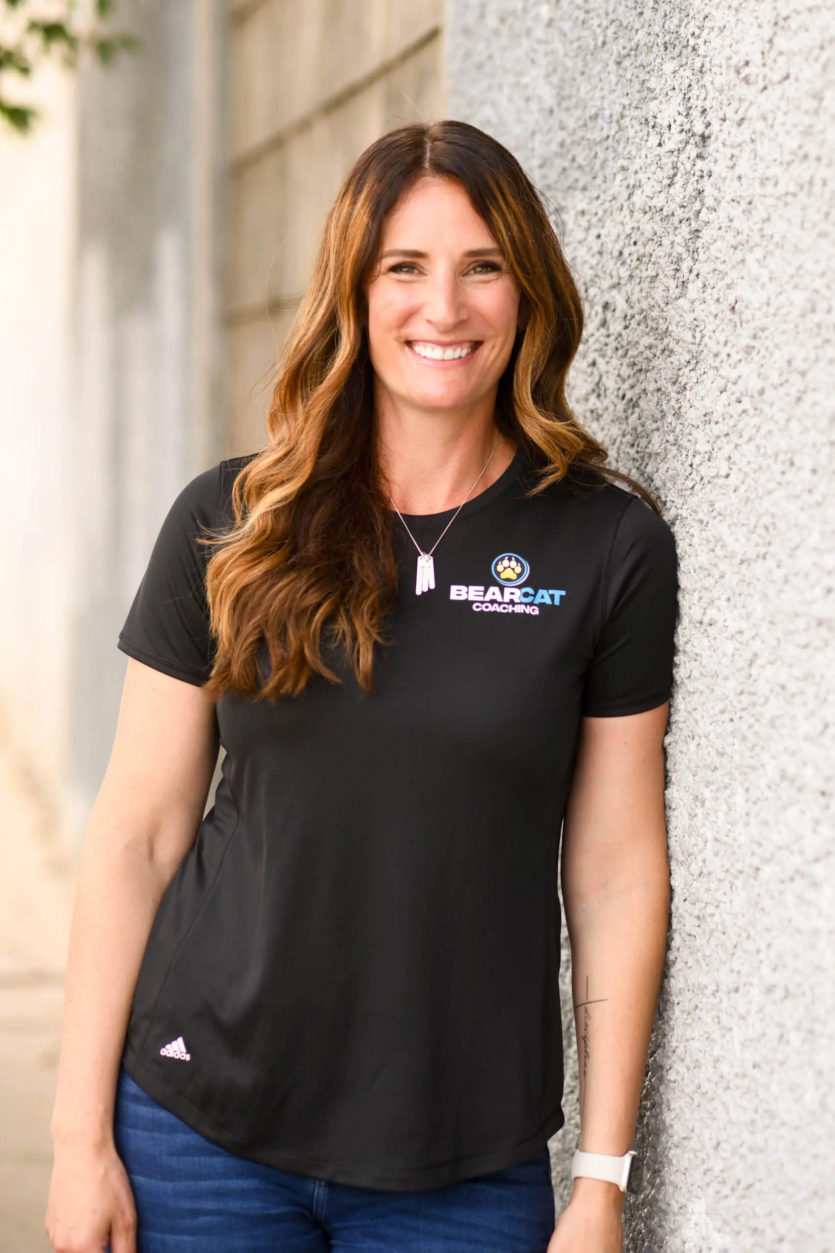 Cathy Helin stands confidently in a Bearcat Coaching polo, representing 25+ years of athlete coaching experience.