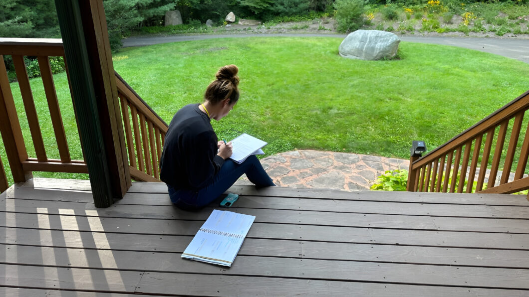 Cathy journals outdoors while developing confidence and resilience with Bearcat Coaching personal growth techniques every single day consistently.