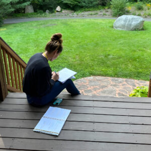 Cathy journals outdoors while developing confidence and resilience with Bearcat Coaching personal growth techniques every single day consistently.
