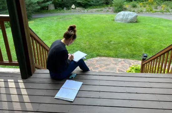 Cathy journals outdoors while developing confidence and resilience with Bearcat Coaching personal growth techniques every single day consistently.