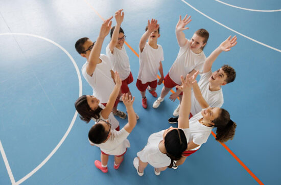Basketball teammates unite before competition while strengthening teamwork through Bearcat Coaching leadership and mindset development together always.