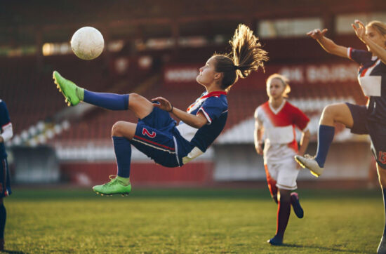 Football athlete demonstrates determination during competition while applying Bearcat Coaching mental performance strategies for success on field.